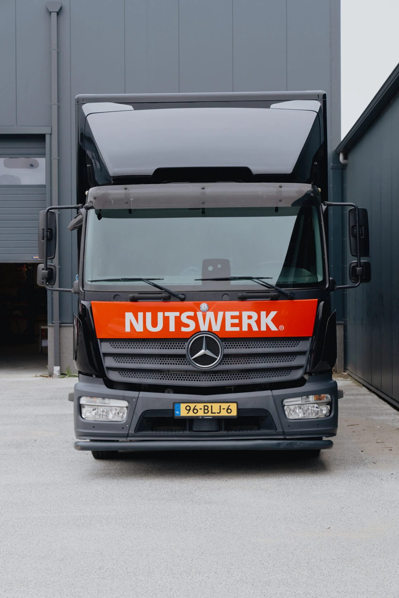 Vooraanzicht vrachtwagen met NUTSWERK-belettering op oranje frontbalk