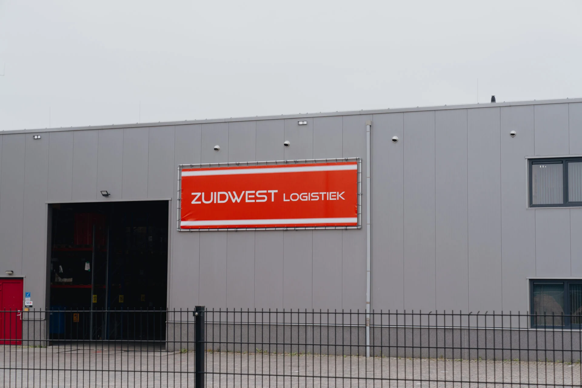 Oranje gevelspandoek Zuidwest Logistiek op bedrijfspand