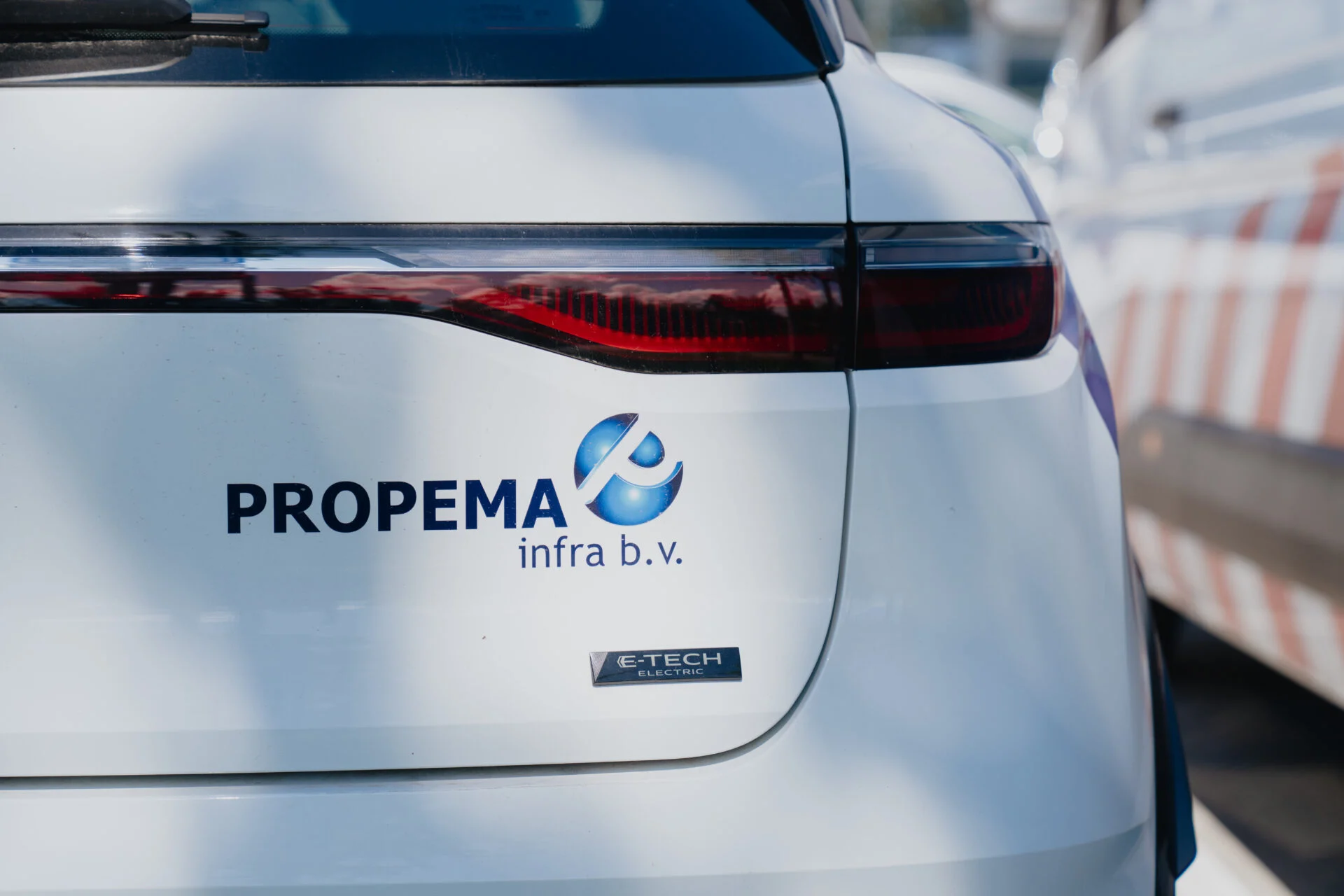 Detail voertuigbelettering Propema infra op achterklep elektrische auto
