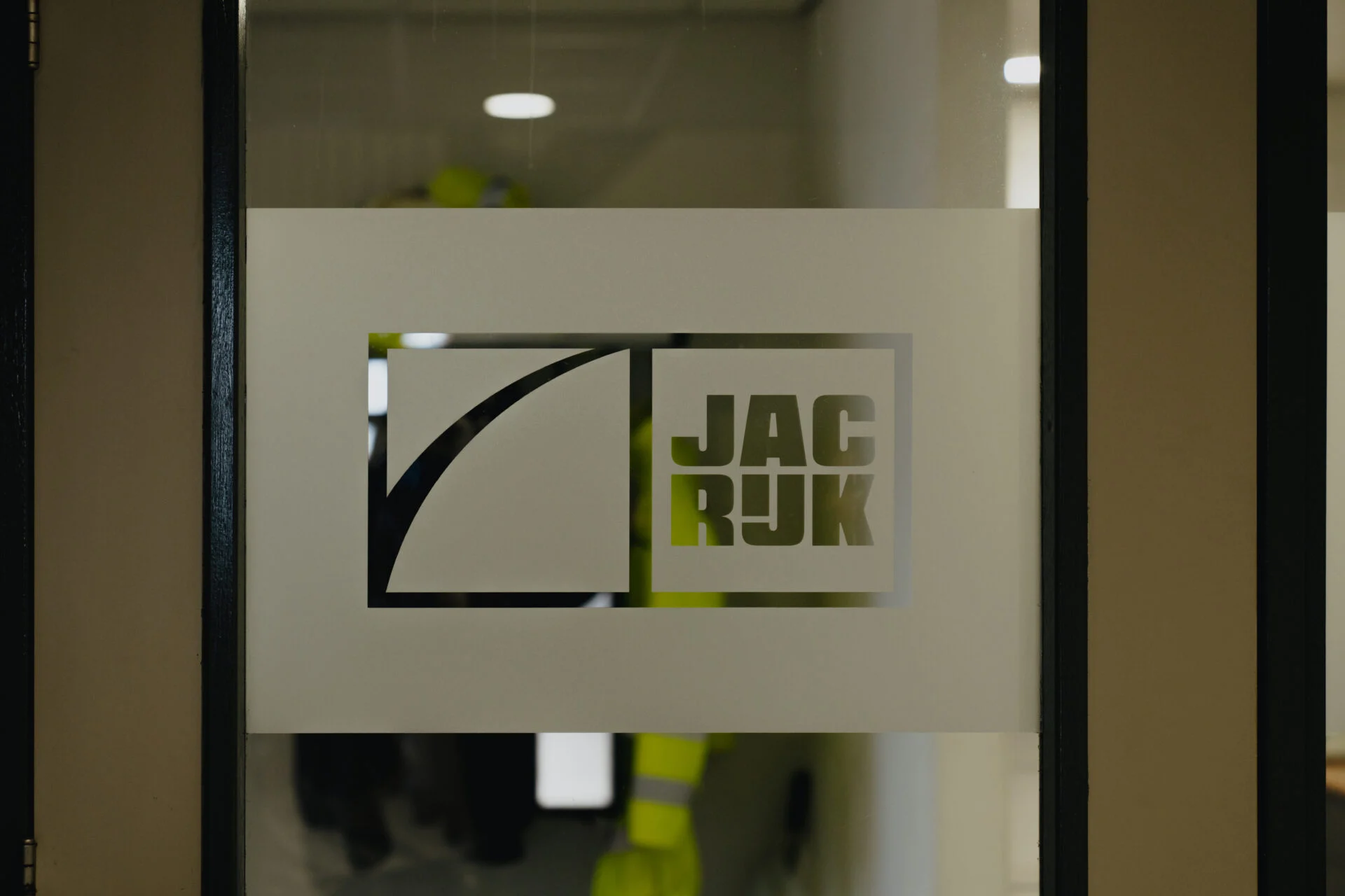 Geëtste raambelettering met Jac Rijk logo op glazen deur