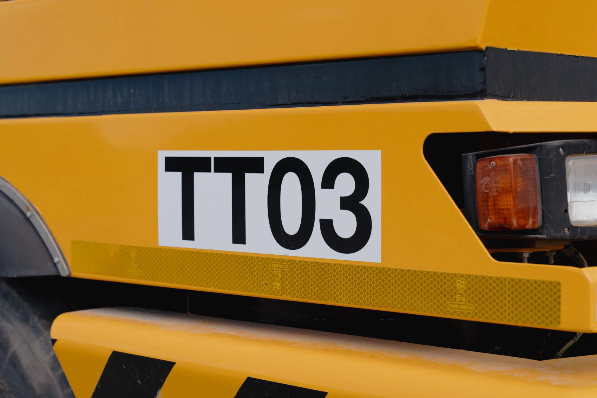 Genummerd kenmerkbordje TT03 op gele machine